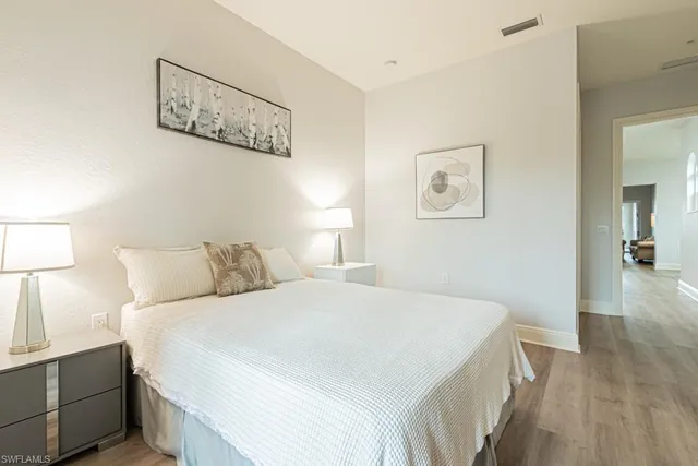 a bedroom with a large bed and a night stand