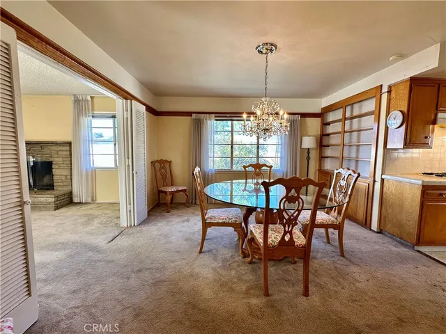 a dining room with furniture a chandelier and fireplace