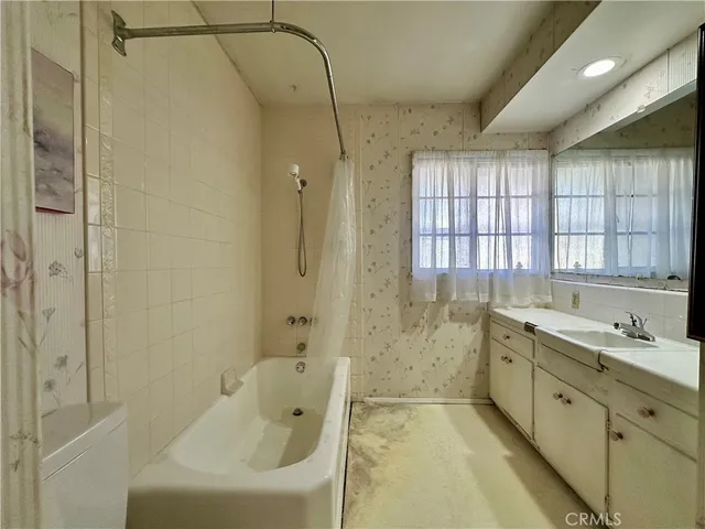 a bathroom with a granite countertop sink a toilet and shower