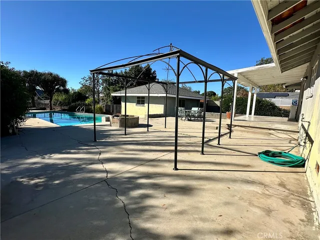 a view of a swimming pool with a bench in patio
