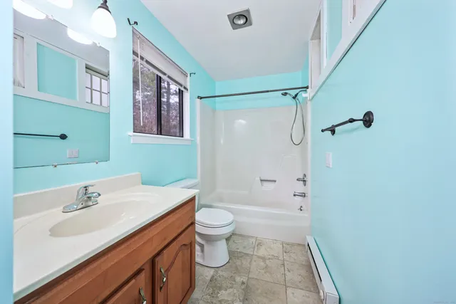 a bathroom with a sink a toilet a shower and a mirror