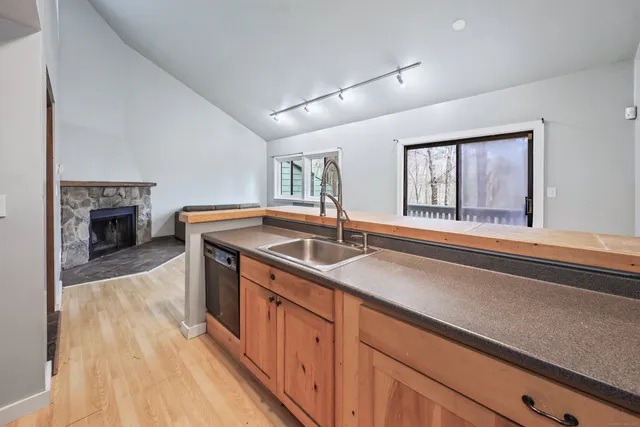 a kitchen with stainless steel appliances granite countertop a sink and a wooden floors