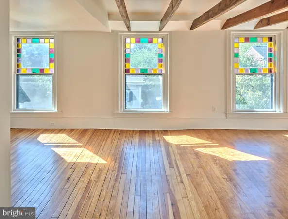a view of a room with wooden floor and a window