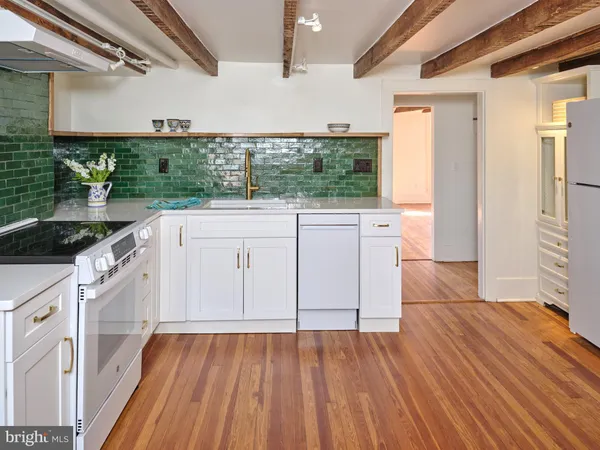 a view of a hallway with wooden floors and cabinet