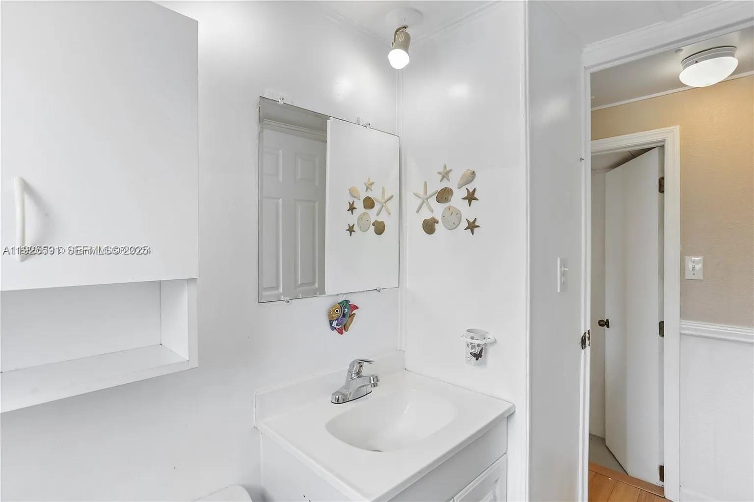 8616 Southwest 16th Place Davie, FL 33324 - Photo 16 of 21 a bathroom with a sink a mirror and a shower