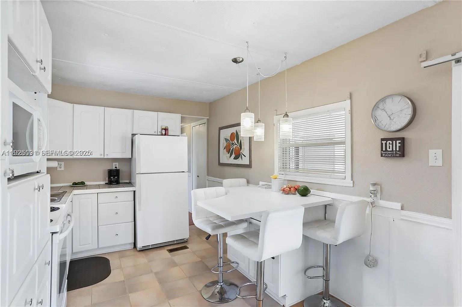 8616 Southwest 16th Place Davie, FL 33324 - Photo 10 of 21 a dining room with stainless steel appliances furniture a large window and a refrigerator