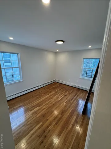 an empty room with wooden floor and cabinet