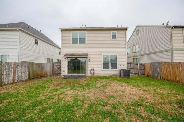 a view of a backyard with plants and large tree