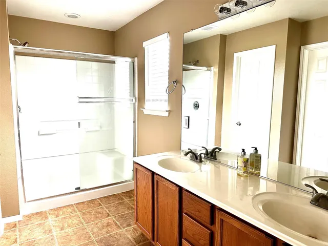 a bathroom with a double vanity sink and a mirror