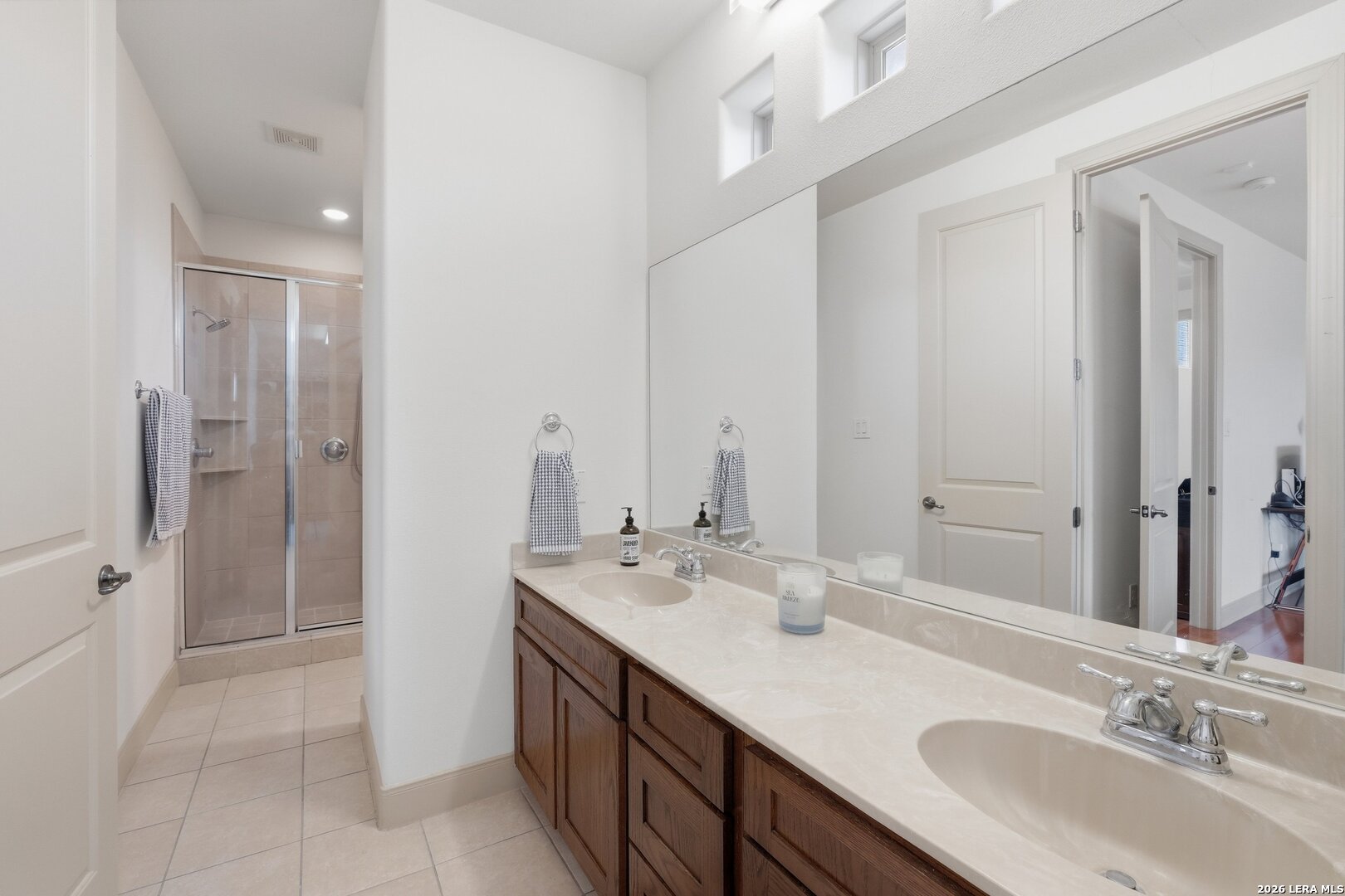 426 Legacy Ridge San Antonio, TX 78258 - Photo 27 of 38 a bathroom with a double vanity sink a mirror and a shower