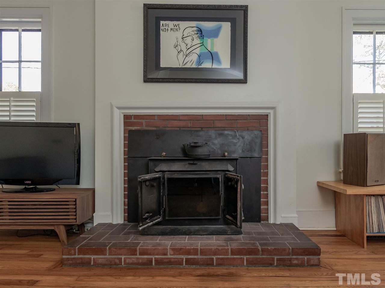 1902 Alexander Road Raleigh, NC 27608 - Photo 7 of 30 a living room with a fireplace and a flat screen tv
