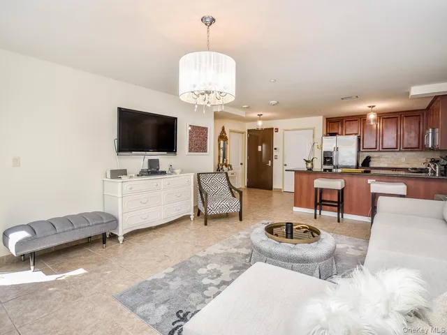 a living room with furniture a flat screen tv and kitchen view