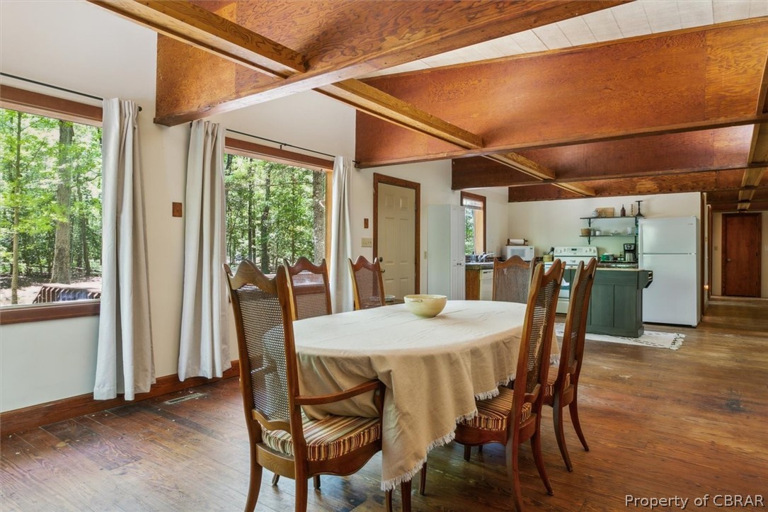 4544 Piney Swamp Road Hayes, VA 23072 - Photo 13 of 48 Dining space with beam ceiling, a wealth of natural light, and dark hardwood / wood-style floors