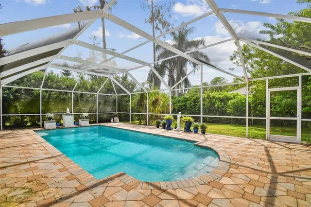a view of a dining room with furniture a chandelier and window