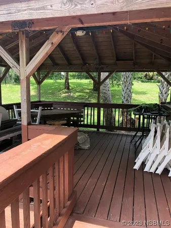 a patio with wooden floor a yard a table and chairs