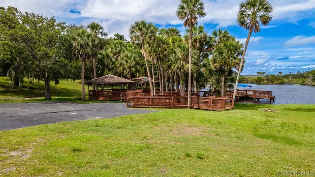 a view of a swimming pool with a patio and a yard