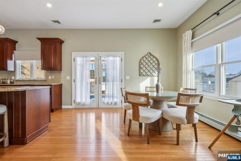 28 George Street Saddle Brook, NJ 07663 - Photo 13 of 50 a dining room with wooden floor a glass table and chairs