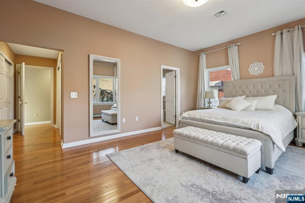28 George Street Saddle Brook, NJ 07663 - Photo 15 of 50 a spacious bedroom with a bed and wooden floor