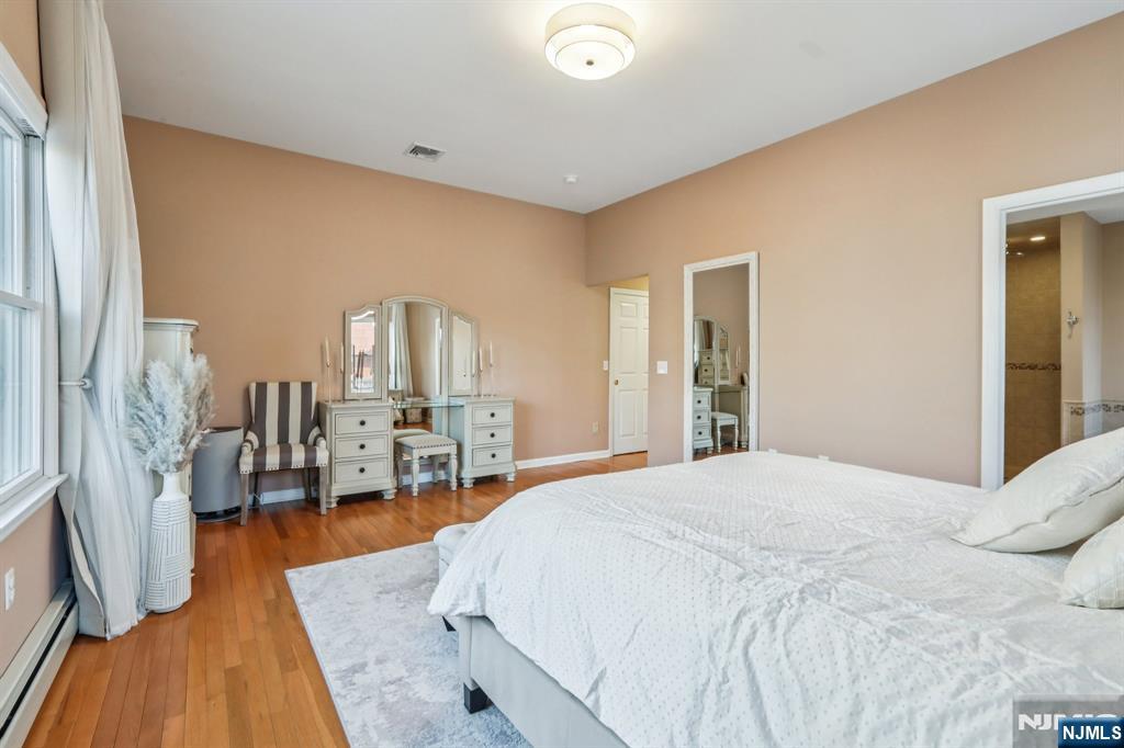 28 George Street Saddle Brook, NJ 07663 - Photo 16 of 50 a spacious bedroom with a bed and wooden floor