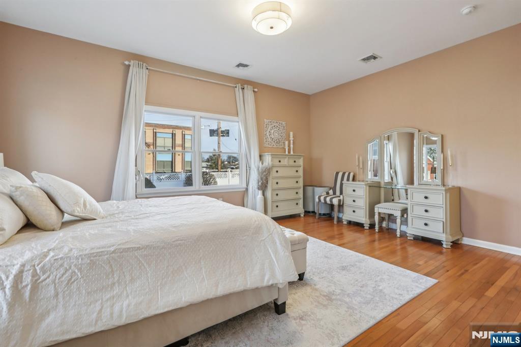 28 George Street Saddle Brook, NJ 07663 - Photo 17 of 50 a spacious bedroom with a bed and wooden floor