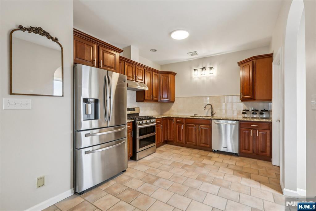 28 George Street Saddle Brook, NJ 07663 - Photo 22 of 50 a kitchen with granite countertop a refrigerator and a stove top oven
