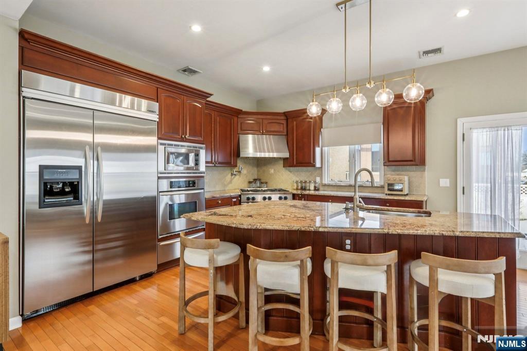 28 George Street Saddle Brook, NJ 07663 - Photo 3 of 50 a kitchen with cabinets a counter space stainless steel appliances and a chandelier