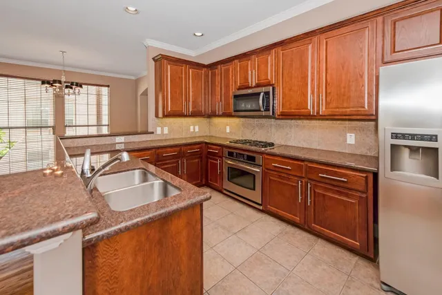 a kitchen with stainless steel appliances granite countertop a sink stove and microwave