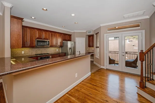 a kitchen with stainless steel appliances granite countertop a refrigerator a stove top oven and a sink with granite countertops