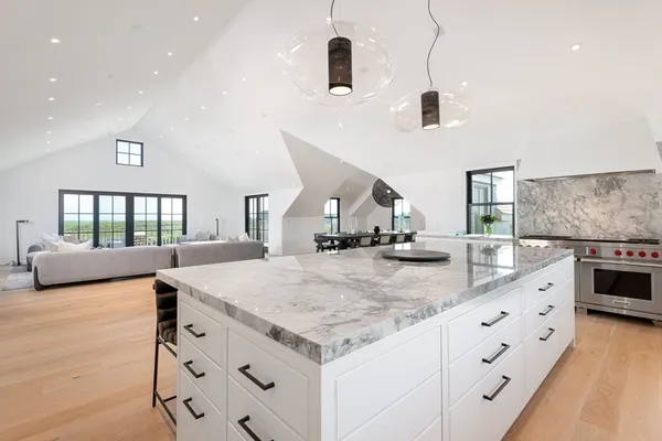 a kitchen with stainless steel appliances kitchen island granite countertop a stove and a sink