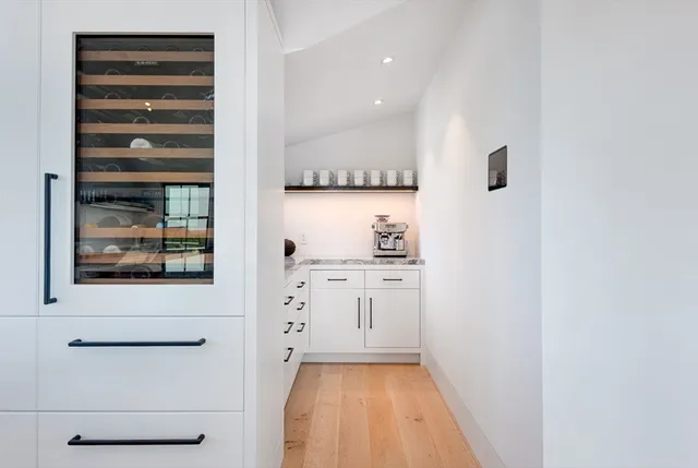 a view of kitchen with wooden floor and cabinets