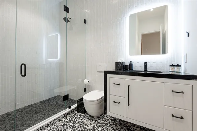 a bathroom with a sink a toilet and shower