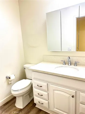 a bathroom with a granite countertop toilet sink and mirror