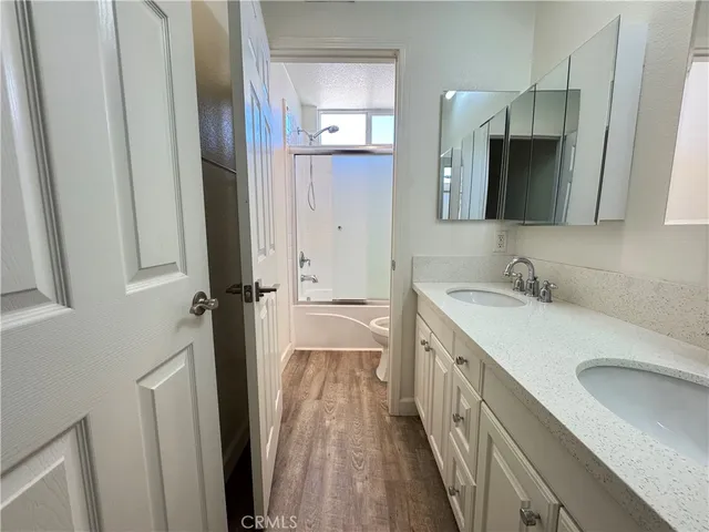 a bathroom with a granite countertop sink a mirror and a shower