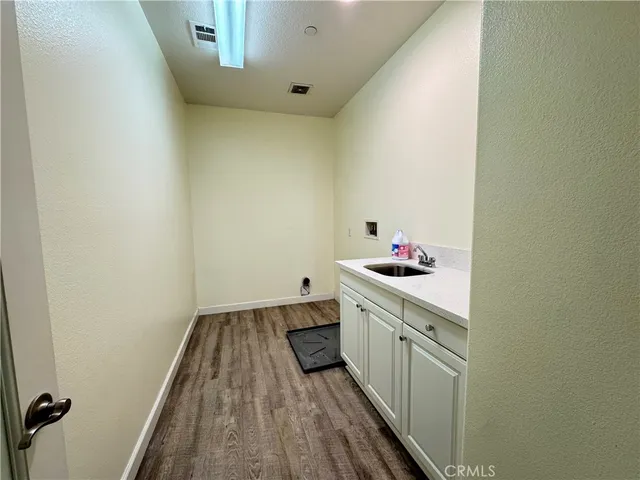 a kitchen with a sink and wooden floor