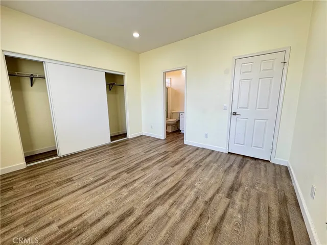 an empty room with wooden floor and closet
