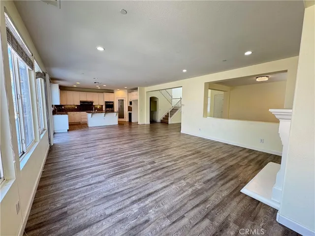 an empty room with wooden floor and furniture
