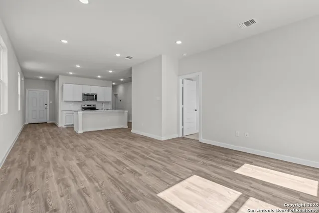 a view of kitchen with granite countertop cabinets and refrigerator