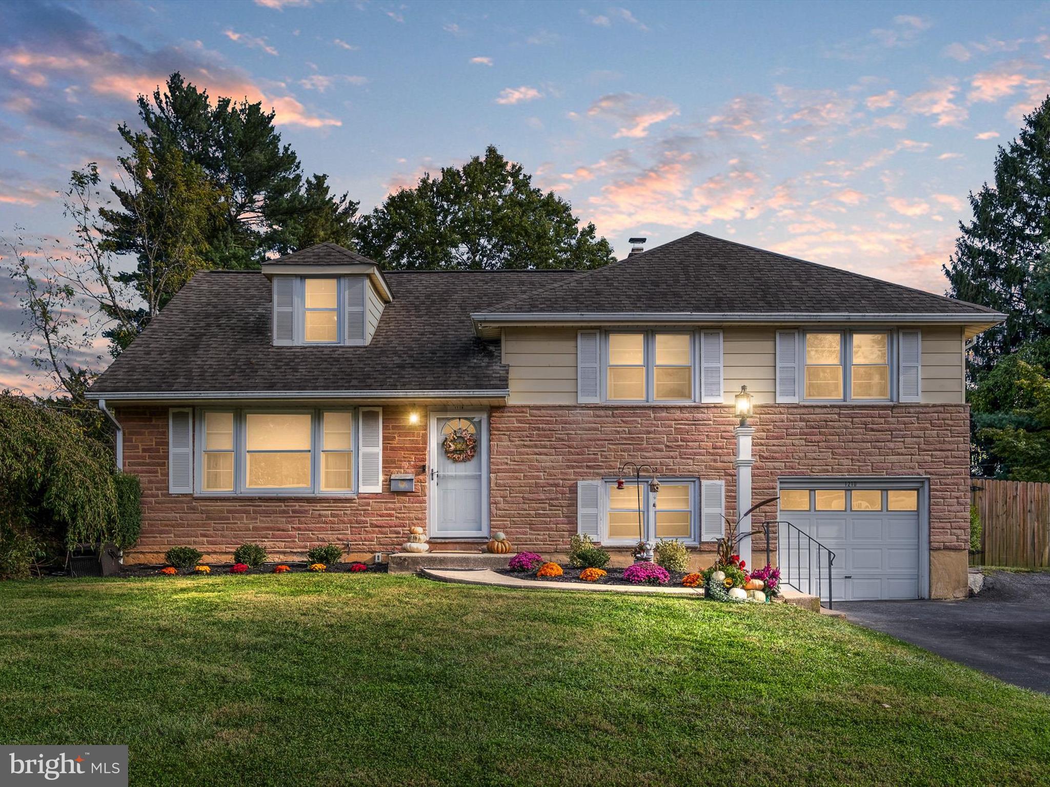 a front view of a house with a garden and yard