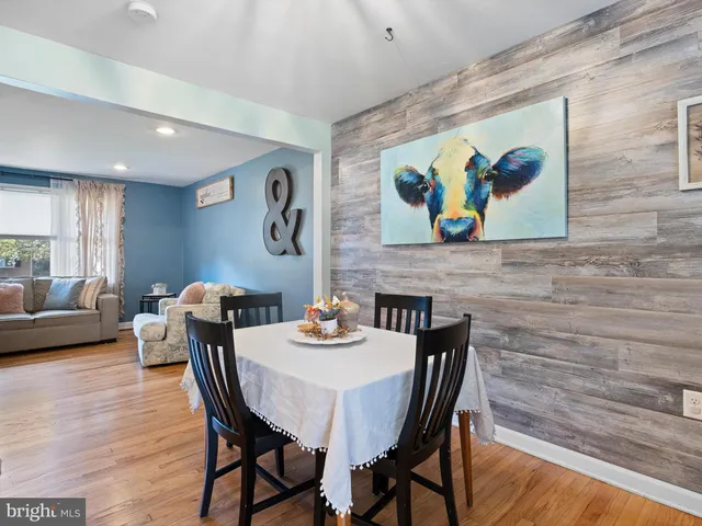 a view of a dining room with furniture a rug and wooden floor