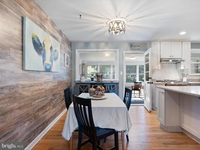 a view of a dining room with furniture a chandelier and wooden floor