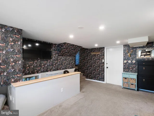 a view of an empty room with kitchen and a window