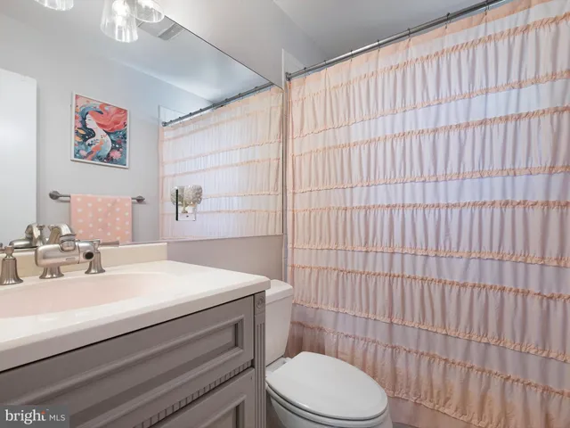 a view of a bedroom with wooden floor and a ceiling fan