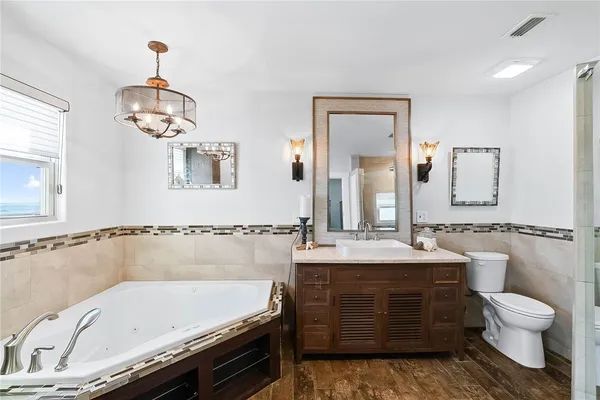 a bathroom with a granite countertop sink a toilet and shower