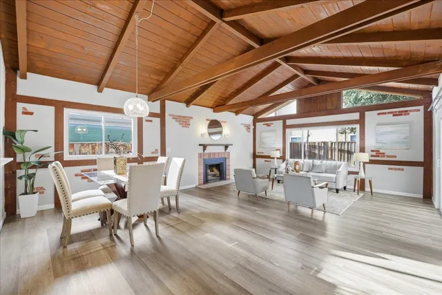 a dining room with wooden floor a glass table and chairs