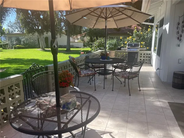 a view of a patio with a table chairs and a backyard