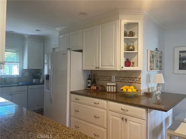 a kitchen with granite countertop a sink stainless steel appliances and cabinets