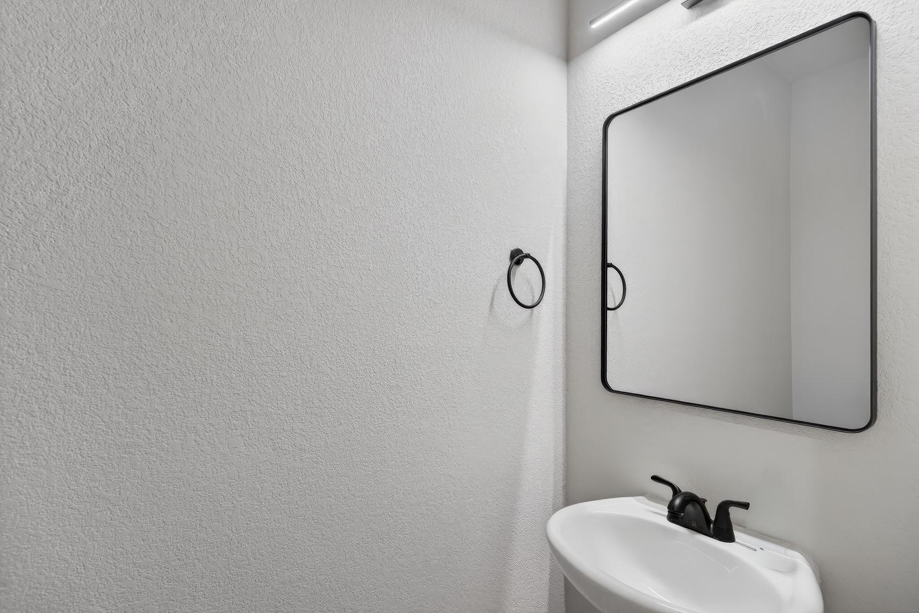 2006 Grow Lane Austin, TX 78754 - Photo 15 of 40 A sleek modern powder room, featuring a clean white sink and minimalist black fixtures.