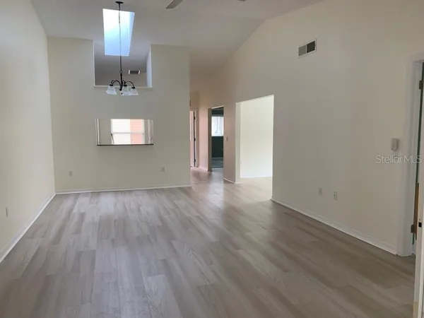 an empty room with wooden floor and mirror