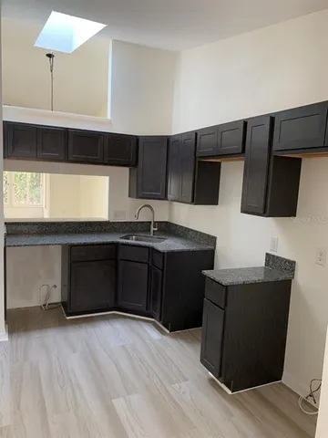 a kitchen with stainless steel appliances granite countertop a sink and a stove top oven