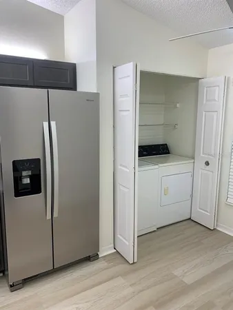 a kitchen with a refrigerator sink and cabinets